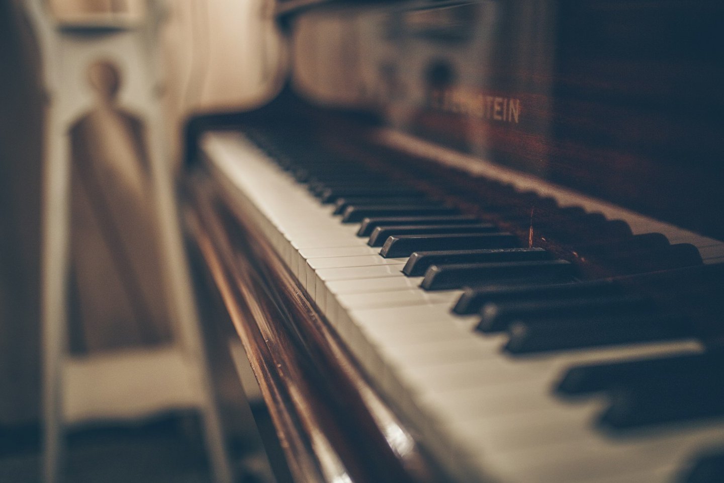 Warm light across the keys of an upright piano